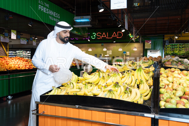 رجل إماراتي يشتري الموز الطازج من السوبر ماركت