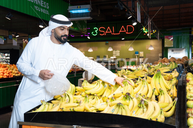 رجل إماراتي يتسوق الموز الطازج في سوبر ماركت