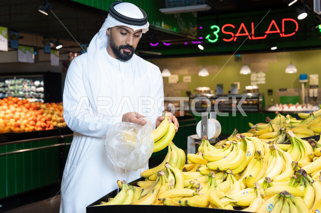 رجل إماراتي يتسوق الموز الطازج في سوبر ماركت بالإمارات
