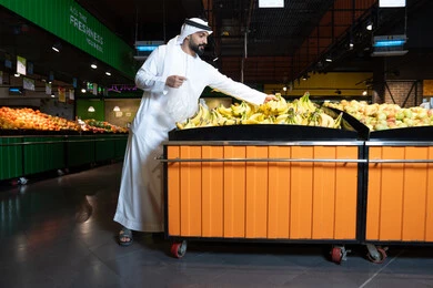رجل إماراتي في قسم الفواكه بالسوبر ماركت
