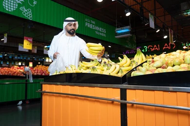 Emirati Man Shopping for Bananas in Supermarket