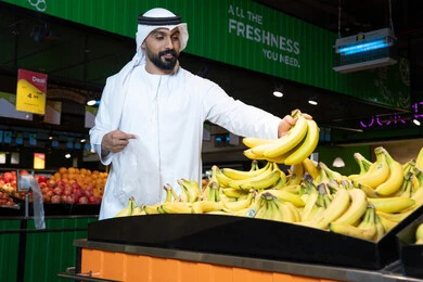 Emirati Man Shopping for Fresh Bananas in Supermarket