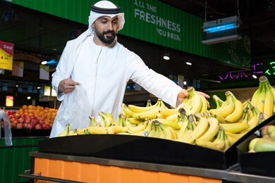 Emirati Man Shopping for Fresh Bananas in Supermarket
