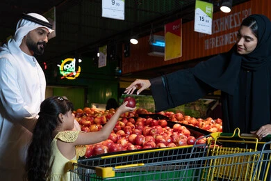 Emirati Family Shopping for Fresh Apples in Supermarket