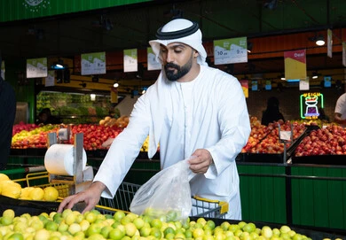 Emirati Man in Supermarket Selecting Fresh Yellow Lemons