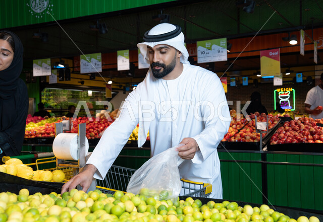 رجل إماراتي يتسوق الليمون الطازج في متجر بالإمارات