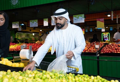 Emirati Man Shopping for Fresh Lemons in UAE Supermarket