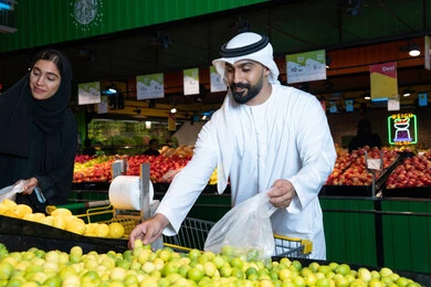 زوجان إماراتيان يتسوقان الفواكه الطازجة في السوبر ماركت