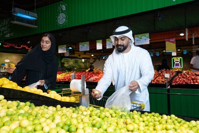 تسوق زوجين إماراتيين للمنتجات الطازجة في السوبر ماركت