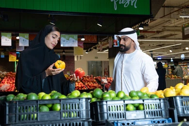 Emirati Couple Shopping for Fresh Produce in Supermarket