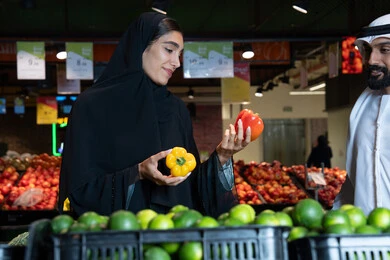 زوجان إماراتيان يتسوقان الخضروات الطازجة في السوبر ماركت