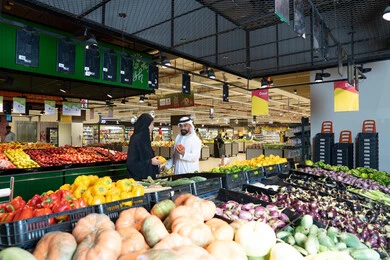 زوجان إماراتيان يتسوقان لشراء الخضروات في السوبر ماركت