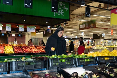 سيدة إماراتية تتسوق الخضروات الطازجة في السوبر ماركت