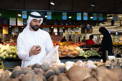 Emirati Man Selecting Fresh Vegetables in Supermarket
