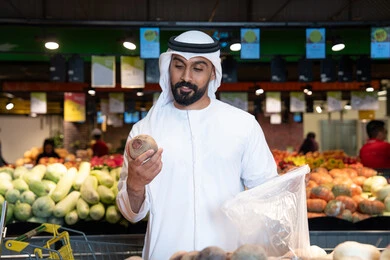 رجل إماراتي يتسوق الخضروات في سوبر ماركت