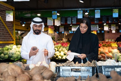 Emirati Couple Shopping for Vegetables in Supermarket