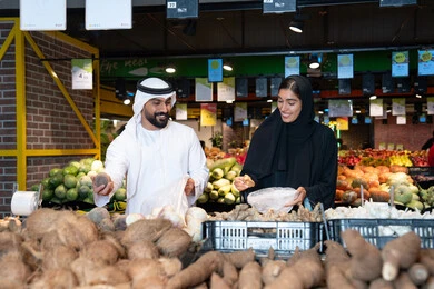 زوجين إماراتيين يتسوقون لمنتجات طازجة في سوبر ماركت