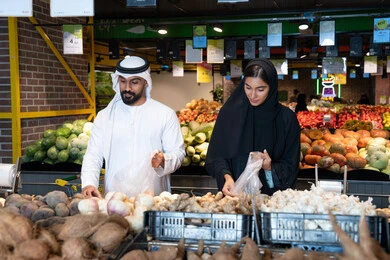 زوجان إماراتيان يتسوقان الخضروات الطازجة في السوبر ماركت