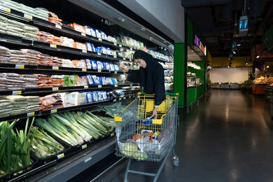 امرأة إماراتية تتسوق الخضروات الطازجة في سوبر ماركت