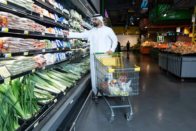 تسوق رجل إماراتي للخضروات في السوبر ماركت