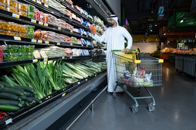 رجل إماراتي يتسوق الخضروات في السوبر ماركت