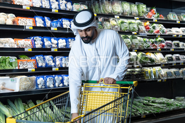 رجل إماراتي يتسوق في السوبر ماركت مع عربة