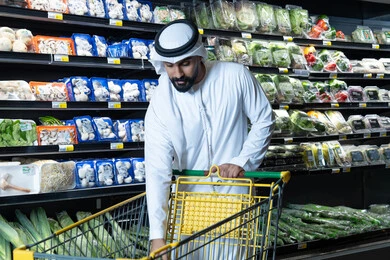 رجل إماراتي يتسوق في السوبر ماركت مع عربة