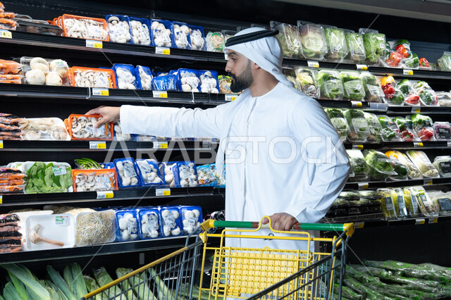 رجل إماراتي يتسوق المنتجات في السوبر ماركت