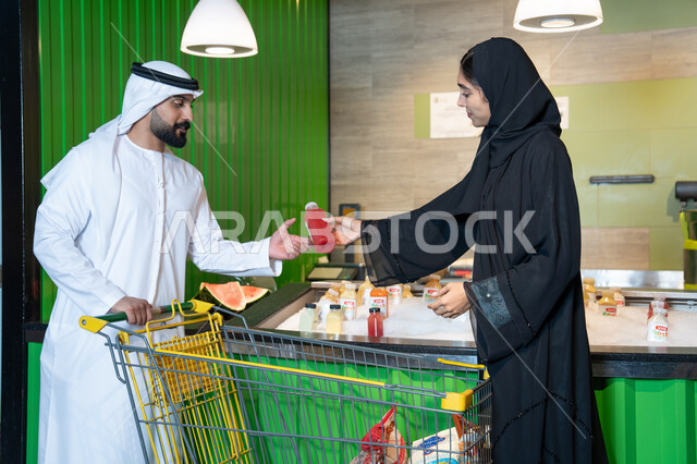 زوجان إماراتيان يتسوقان العصائر الطازجة في السوبر ماركت