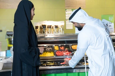 Emirati Couple Shopping for Fresh Fruit at Salad Bar