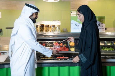 Emirati Couple at Grocery Store Salad Bar