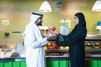 Emirati Couple Shopping for Fresh Fruit in Supermarket