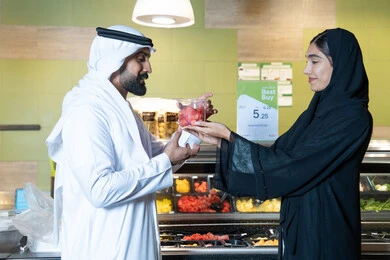 Emirati Couple Shopping for Fresh Fruit in Supermarket