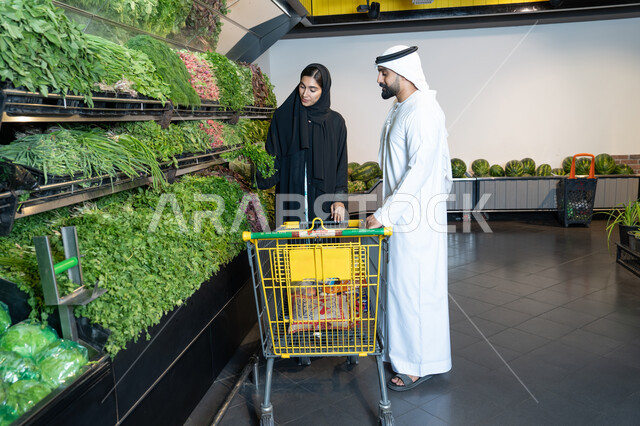 زوجان إماراتيان يتسوقان الخضروات الطازجة في السوبر ماركت