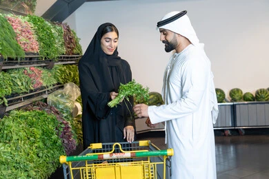 تسوق زوجان إماراتيان للخضروات الطازجة في السوبر ماركت
