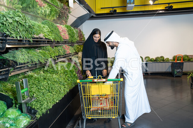 زوجين إماراتيين يتسوقان الخضروات الطازجة في السوبر ماركت