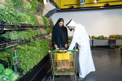 زوجين إماراتيين يتسوقان الخضروات الطازجة في السوبر ماركت