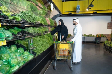 زوجان إماراتيان يتسوقان الخضروات الطازجة في السوبر ماركت