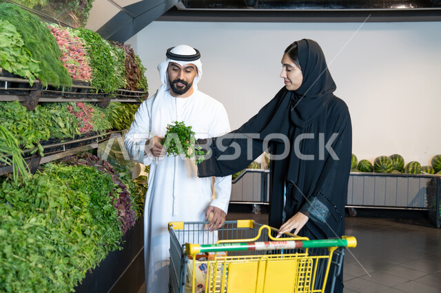 زوجين إماراتيين يتسوقون الخضروات الطازجة في السوبر ماركت
