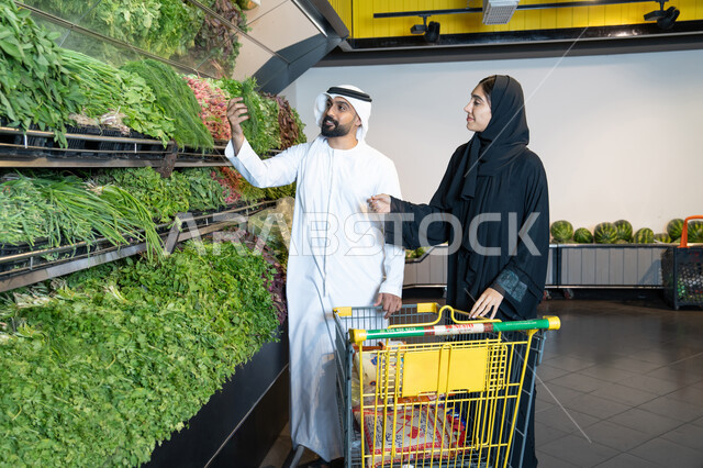 زوجان إماراتيان يتسوقان الخضروات الطازجة في السوبر ماركت