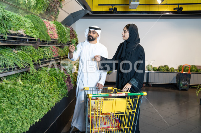 زوجين إماراتيين يتسوقان الخضروات الطازجة في المتجر