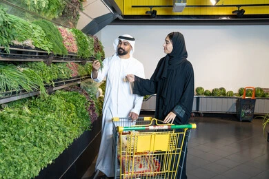 زوجين إماراتيين يتسوقان الخضروات الطازجة في المتجر