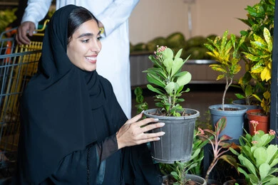 امرأة إماراتية تتسوق النباتات في مشتل منزلي