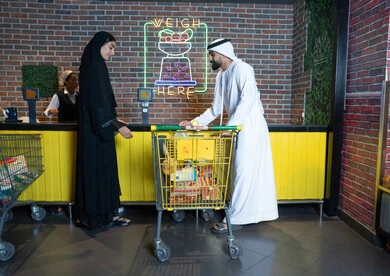 Emirati Couple Shopping at Supermarket Checkout