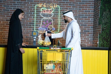 زوجان إماراتيان يتسوقان في محطة وزن بالسوبر ماركت