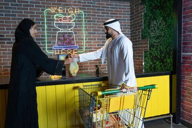 رجل وامرأة من الإمارات يتسوقان في متجر البقالة