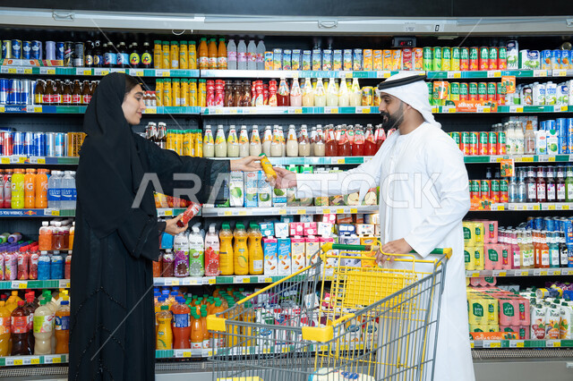 زوجان إماراتيان يتسوقان المشروبات في السوبر ماركت