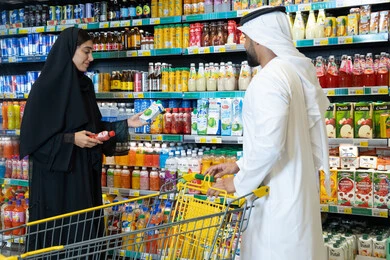 Emirati Couple Grocery Shopping in Supermarket Aisle