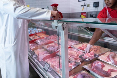 Emirati Man Buying Fresh Meat at Supermarket Butcher