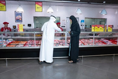 Emirati Couple at Supermarket Butcher Counter